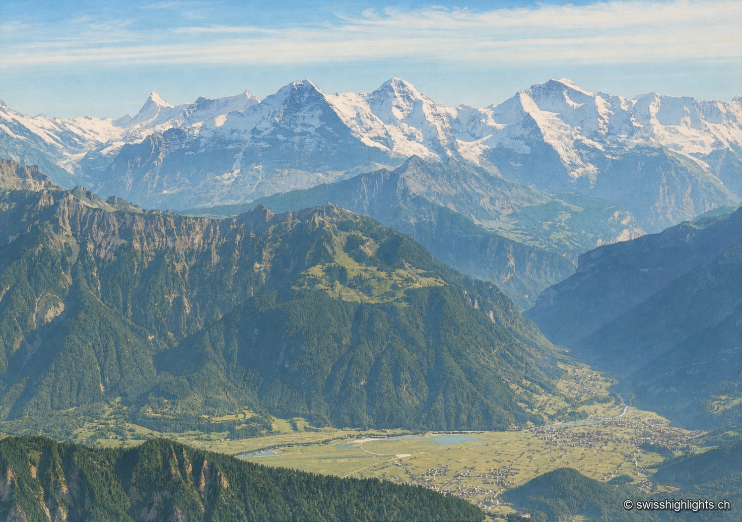 Panorama ancien, colorisé, d'Interlaken : les crêtes étagées, les sommets enneigés et l'implantation du village dans la vallée se lisent nettement sous une lumière d'archive adoucie.