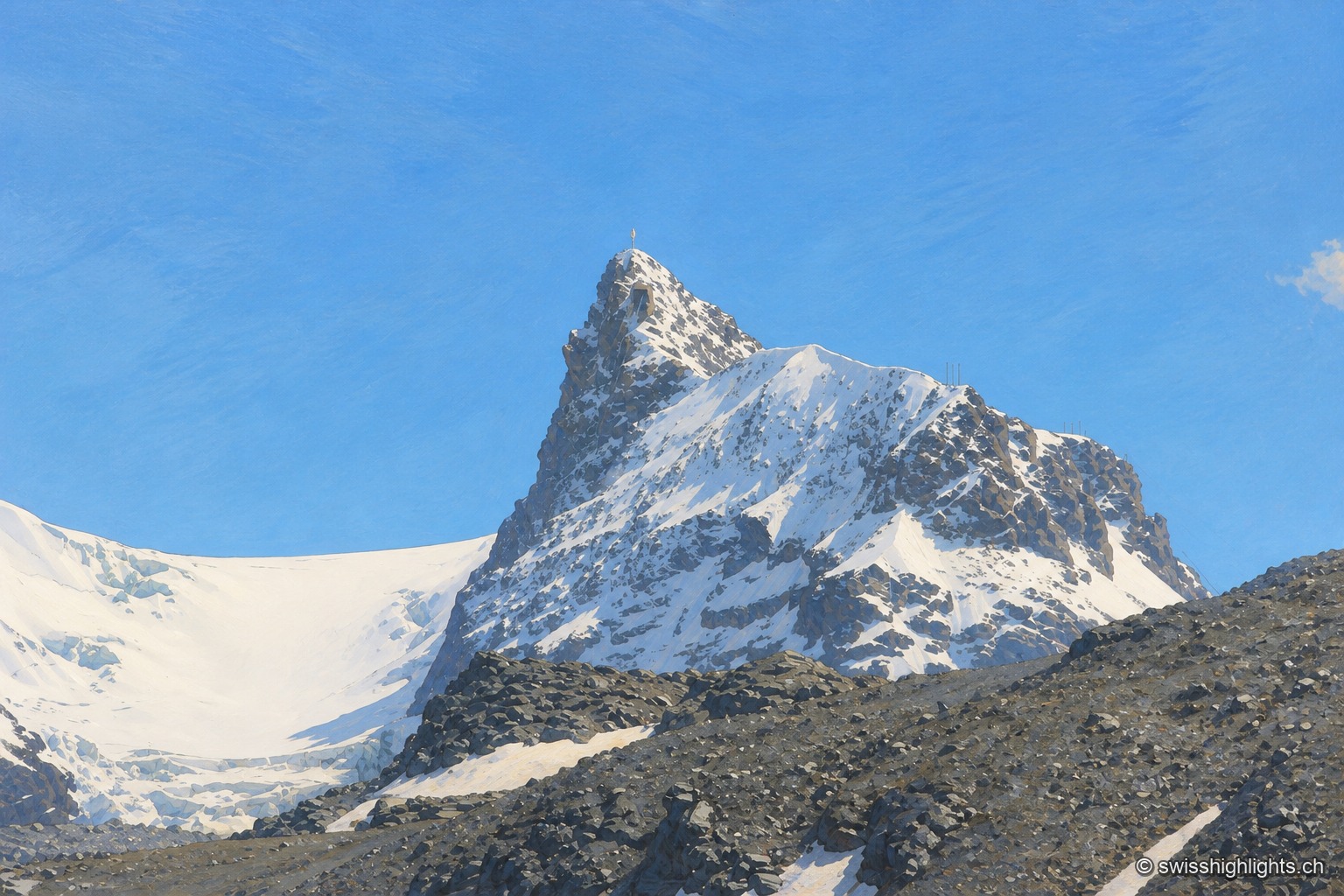 Vue rapprochée de la pointe rocheuse et enneigée du Petit Cervin, émergeant d'un glacier crevassé sous un ciel bleu dégagé.